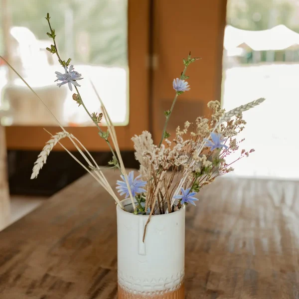 Boeketje veldbloemen op tafel in de Kokua safaritent