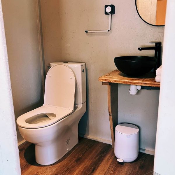 Salle d'eau privée dans la tente safari Fuji Rock, équipée de toilettes et d'un lavabo moderne encastré