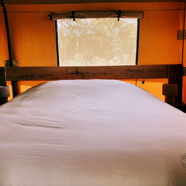 Lit double confortable dans la chambre parentale de la tente safari Fuji Rock au Festilux Camp